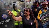 Saat demo berlangsung, seorang guru berteriak mengeluh tentang gajinya di depan barisan polisi.  