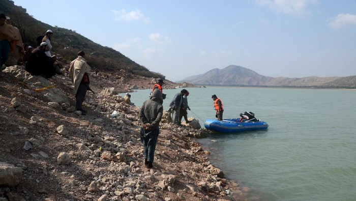 PESHAWAR, PAKISTAN, JANUARY, 30: Rescue workers perform a search operation for bodies after a boat capsized in Kohat dam, Pakistan, 30 January 2023. At least 50 children on Sunday died as a boat, carrying 50 to 55 passengers including madrassa students as well as the boatman, capsized in Kohatâs Tanda Dam, while the authorities were still searching for the rest of them. (Photo by Hussain Ali/Anadolu Agency via Getty Images)
