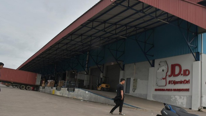 Seorang pekerja melintas di depan gudang JD.ID, Kabupaten Bekasi, Jawa Barat, Selasa (31/1/2023). Layanan belanja daring JD.ID melalui web resmi perusahaan mengumumkan akan menyetop menerima pesanan mulai 15 Februari 2023 dan akan menutup total pelayanannya di Indonesia pada 31 Maret 2023. ANTARA FOTO/Fakhri Hermansyah/tom.