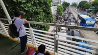 Para pelajar melihat kemacetan dari JPO.