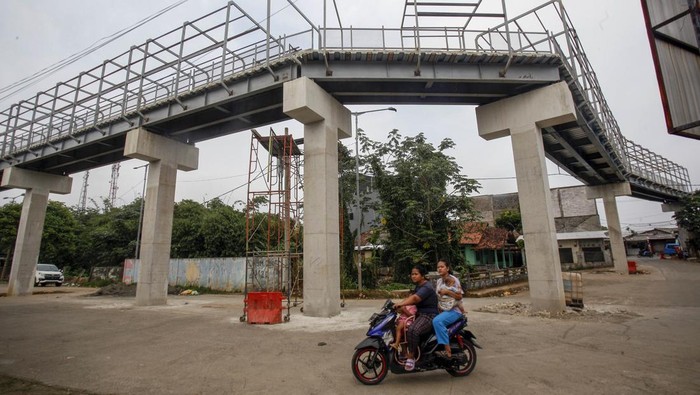 Pekerja menyelesaikan proyek pembangunan jembatan multiguna (skybridge) di Bojonggede, Kabupaten Bogor, Jawa Barat, Senin (30/1/2023). Pembangunan Skybridge tersebut merupakan proyek kerja sama Badan Pengelola Transportasi Jabodetabek (BPTJ) dengan Pemkab Bogor yang akan menghubungkan stasiun dengan terminal Bojonggede, dan pembangunan konstruksi skybridge itu telah mencapai 90 persen. ANTARA FOTO/Yulius Satria Wijaya/foc.