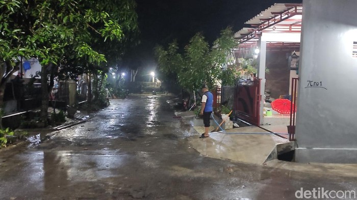 Warga membersihkan bekas genangan di Perum Dinar Indah Semarang, Selasa (31/1/2023).