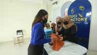 Seorang pelanggan hendak menitipkan tasnya untuk perawatan di salah satu gerai Cuci Factory.