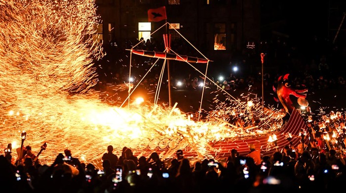 Participants take part in the Up Helly Aa festival parade through the streets of Lerwick, Shetland Islands on January 31, 2023. - Up Helly Aa celebrates the influence of the Scandinavian Vikings in the Shetland Islands and culminates with up to 1,000 'guizers' (men in costume) throwing flaming torches into their Viking longboat and setting it alight later in the evening. (Photo by Andy Buchanan / AFP) (Photo by ANDY BUCHANAN/AFP via Getty Images)