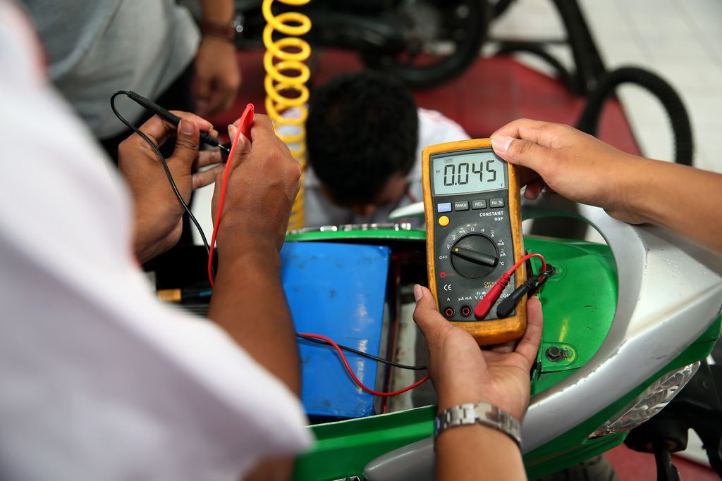 Siswa mengecek kondisi motor listrik sebelum diuji coba di SMKN 1 Nglegok, Blitar, Jawa Timur, Rabu (1/2/2023). Prototipe motor listrik karya siswa SMKN 1 Nglegok yang diberi nama Gili-1 tersebut digerakkan menggunakan baterai jenis Lithium ION berkapasitas 72 volt 20 AH sehingga mampu menempuh jarak 60 hingga 75 kilometer dengan kecepatan antara 94 hingga 99 kilometer per jam. ANTARA FOTO/Irfan Anshori/nym.