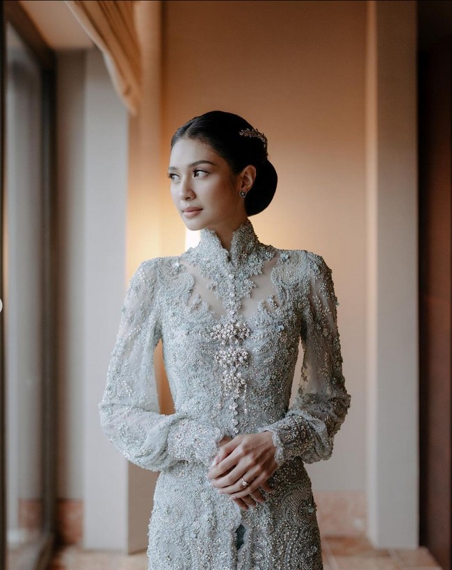 Mikha Tambayong juga mengunggah foto lain momen pernikahannya. Dia tampak memakai busana adat Sulawesi dengan sentuhan modern. Kebaya pengantin yang dikenakannya dipadu dengan kain tenun khas Makassar berwarna hijau. Foto: Instagram/@miktambayong