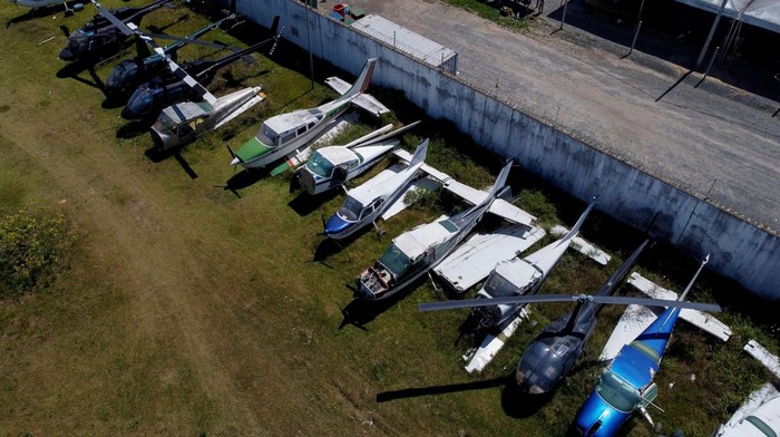 Polisi Brasil Sita Puluhan Helikopter-Pesawat dari Tambang Ilegal Planes and helicopters seized by the police during operations against illegal mining on indigenous territories are seen at the courtyard of the Federal Police headquarters in Boa Vista, Roraima state, Brazil on January 31, 2023. (Photo by MICHAEL DANTAS / AFP) (Photo by MICHAEL DANTAS/AFP via Getty Images)