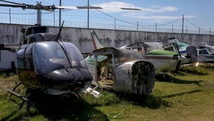 Polisi Brasil Sita Puluhan Helikopter-Pesawat dari Tambang Ilegal Planes and helicopters seized by the police during operations against illegal mining on indigenous territories are seen at the courtyard of the Federal Police headquarters in Boa Vista, Roraima state, Brazil on January 31, 2023. (Photo by MICHAEL DANTAS / AFP) (Photo by MICHAEL DANTAS/AFP via Getty Images)