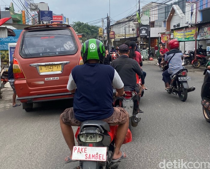 Potret pengendara motor di Bekasi pakai pelat nyeleneh.