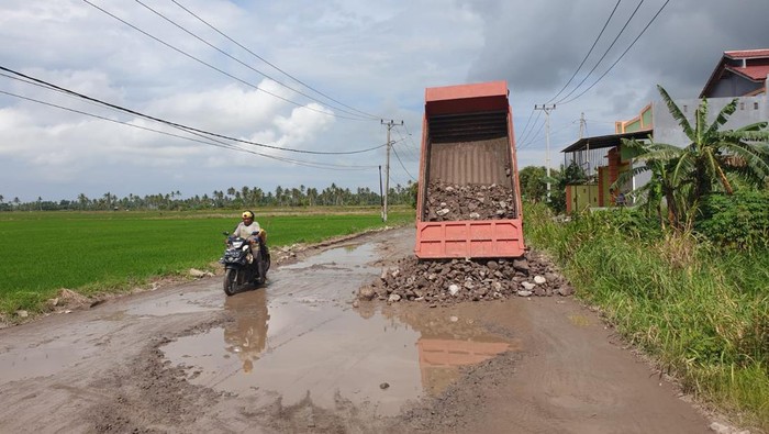 Proses penimbunan jalan berlubang di Pinrang yang dikeluhkan warga.