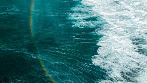Terakhir, pelangi ini muncul diantara deburan ombak raksasa di Hawaii. Fenomena langka ini dijepret pada 22 Januari 2023. Donald Miralle/Getty Images