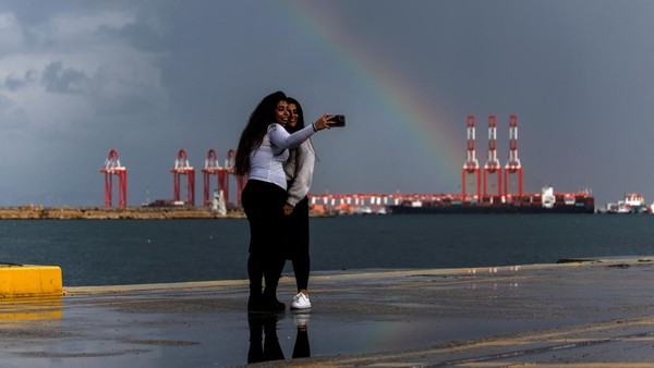 Dari Israel, dua orang wanita terlihat asyik swafoto dengan latar belakang penampakan pelangi di kawasan Mediterania, tepatnya di Pelabuhan Adani, Haifa, pada 31 Januari 2023 lalu. REUTERS/Amir Cohen Dari Israel, dua orang wanita terlihat asyik swafoto dengan latar belakang penampakan pelangi di kawasan Mediterania, tepatnya di Pelabuhan Adani, Haifa, pada 31 Januari 2023 lalu. REUTERS/Amir Cohen