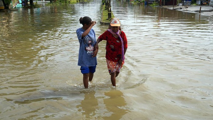 Diguyur Hujan Lebat, Kawasan Kota Sorong Terendam Banjir Warga mendorong sepeda motor akibat mogok saat menerjang genangan banjir di Jalan Sungai Maruni Kota Sorong, Papua Barat Daya, Kamis (2/2/2023). BMKG stasiun Metereologi kelas I Domine Edward Osok Sorong mengeluarkan peringatan dini cuaca untuk wilayah Papua Barat dan Papua Barat Daya, dimana sejumlah wilayah di