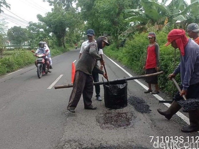 Jalan berlubang yang ditambal tukang becak Lamongan telah diperbaiki sementara oleh pemkab.