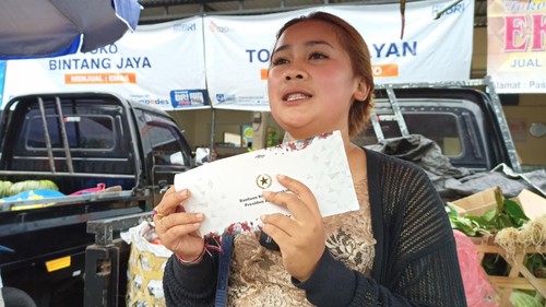 Ni Wayan Winarsih, pedagang limau di Pasar Baturiti, Tabanan, Bali, menunjukkan amplop berisi BLT yang diberikan Presiden Jokowi, Rabu (2/2/2023). (Foto: chairul amri simabur/detikBali)