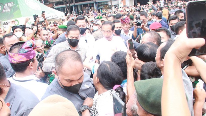 Para pedagang di Pasar Anyar Singaraja menyambut Presiden Jokowi dengan riuh. Mereka bahkan berebut bersalaman dengan Jokowi.