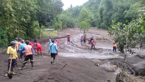 Petugas BPBD Kabupaten Karangasem membersihkan akses jalan yang tertutup material pasir dan bebatuan akibat banjir bandang di Desa Pempatan, Kecamatan Rendang, Karangasem, Bali, Kamis (2/2/2023). (Forto: Istimewa)