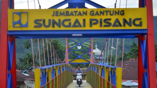 Warga melintas di Jembatan Gantung Sungai Pisang, Bungus Teluk Kabung, Padang, Sumatera Barat, Kamis (2/2/2023). Jembatan Gantung Sungai Pisang berdiri di atas Sungai Pisang dengan panjang bentang 42 meter.