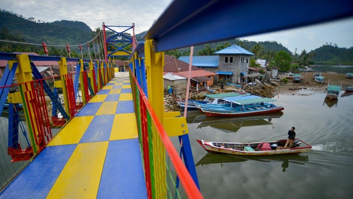 Tampil Warna-warni Percantik Jembatan Gantung Sungai Pisang Warga melintas di Jembatan Gantung Sungai Pisang, Bungus Teluk Kabung, Padang, Sumatera Barat, Kamis (2/2/2023). Kementerian PUPR telah menyelesaikan pembangunan Jembatan Gantung Sungai Pisang dengan biaya Rp3,6 milliar, sebagai salah satu infrastruktur kerakyatan sekaligus penunjang akses pariwisata menuju Pulau Pasumpahan, Pulau Pamutusan, dan Pulau Sikuai.