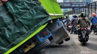 Kendaraan bermuatan penuh tersebut berjalan terlalu minggir hingga turun dari aspal dan melewati beton penutup gorong-gorong U ditch.