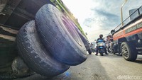 Badan truk miring hingga roda belakang bagian kanan sampai terangkat dari aspal.