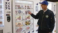 Konomu Kubo, juru bicara Kyodo Senpaku Co. menjelaskan cara kerja mesin penjual otomatis yang menjual daging ikan paus di Yokohama, Jepang, Kamis (26/1/2023).  