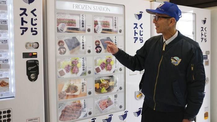 Vending Machine di Jepang Jual Daging Ikan Paus, Tuai Kontroversi Staff of Kyodo Senpaku Co. pointing to an image of whale meat being sold from a vending machine at the firm's unmanned store, Thursday, Jan. 26, 2023, in, Yokohama, Japan. (AP Photo/Ha Kwyeon)