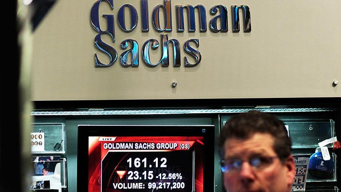 NEW YORK - APRIL 16:  A financial professional works in the Goldman Sachs booth on the floor of the New York Stock Exchange while a television reports airs about the companys lowered stock price April 16, 2010 in New York, New York.  Goldman Sachs was charged with fraud by the Securities and Exchange Commission over its marketing of a subprime mortgage product, sending its stock price sharply lower.  (Photo by Chris Hondros/Getty Images)
