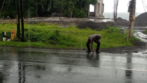 Anggota Satlantas Polres Karangasem saat melakukan olah TKP di lokasi kejadian di Jalan Raya Amlapura-Singaraja, tepatnya di depan Dermaga Toya Anyar, Banjar Dinas Darmawinangun, Desa Tianyar, Kecamatan Kubu, Kabupaten Karangasem, Bali, Kamis (2/2/2023). (Foto: Istimewa)