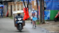 Plastik merah sebagai penanda ini dipasang oleh warga sekitar. Harapannya, kabel itu tidak mengenai pengendara yang melintas di jalan tersebut.