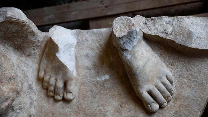The feet belonging to a life-sized statue of a Roman emperor posing as the classical hero Hercules lie on a wooden pallet after they were discovered during sewer repair works near the old Appian Way, ancient Rome's first highway, in Rome, Italy, February 1, 2023. REUTERS/Guglielmo Mangiapane