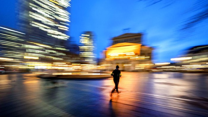Bingkai Sepekan: Merapal Doa dalam Gurat-gurat Warna A man runs in the square in front of the Old Opera in Frankfurt, Germany, Tuesday, Jan. 31, 2023. (AP Photo/Michael Probst)