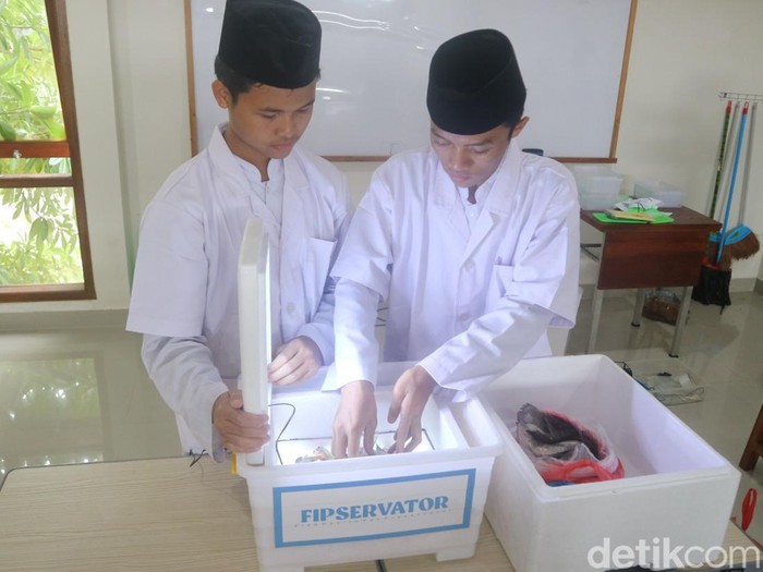 Dua siswa SMAQT Yanbul Quran 1 Pati memeragakan penggunaan Fipservator, alat pengawet ikan berbasis antibakteri, Jumat (3/2/2023).