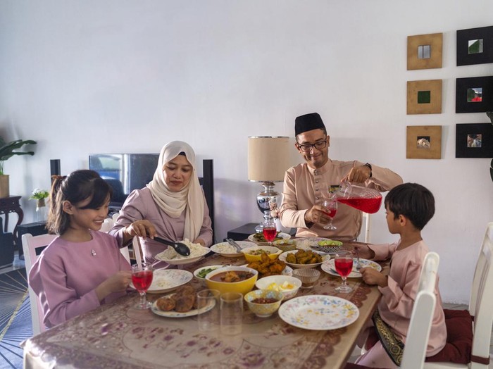 happy muslim family ready for Iftar or breaking fast meal in Ramadan.
