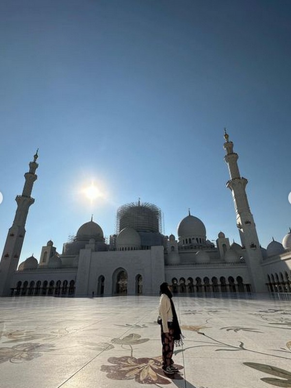 Jennie mengenakan pakaian tertutup dengan pasmina hitam untuk kepalanya. Saat berkeliling dia juga memakai kacamata hitam.