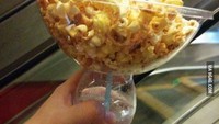 Pergi ke bioskop, memang paling enak menyantap minuman dingin dan popcorn. Gelas yang satu ini berisi minuman, dan wadah besar untuk menaruh popcorn di atasnya. Foto: Pool/Site