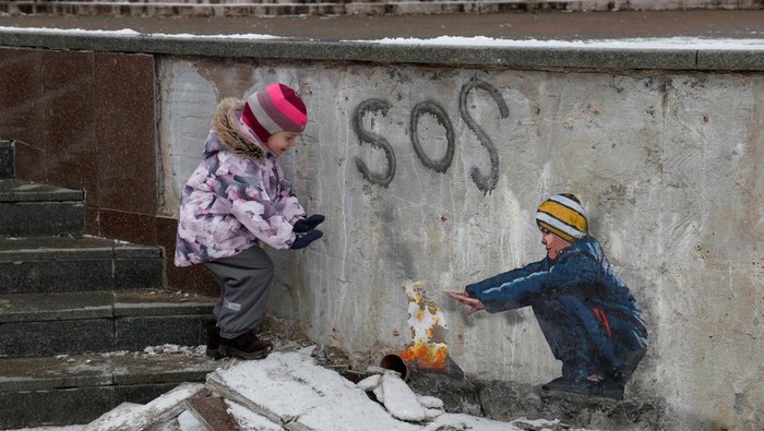 Anastasia, 4, stands next to an artwork of the famous street artist Tvboy in the town centre, amid Russia's attack on Ukraine, in Bucha, outside Kyiv, Ukraine January 29, 2023. REUTERS/Valentyn Ogirenko     TPX IMAGES OF THE DAY