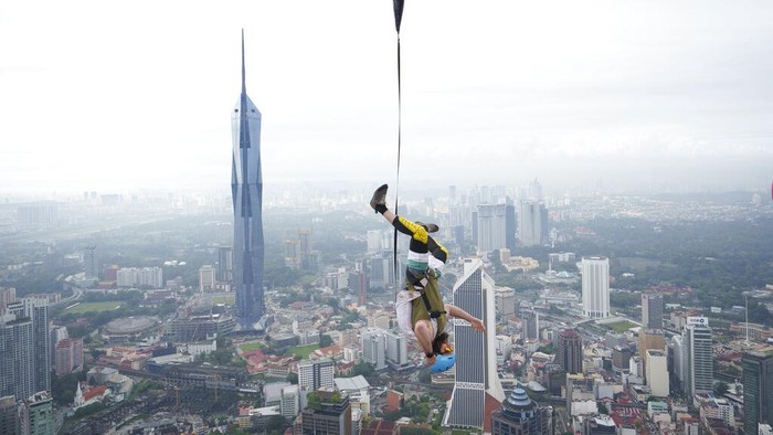 A BASE jumper dives from the Kuala Lumpur Tower during the KL Tower International Jump in Kuala Lumpur, Malaysia, Friday, Feb. 3, 2023. BASE stands for buildings, antennas, spans and Earth. (AP Photo/Vincent Thian)