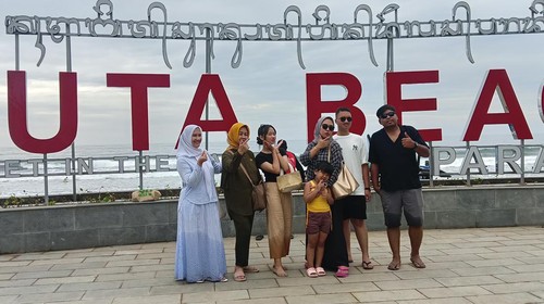 Papan bertuliskan Kuta Beach Sunset In the Last Paradise di Pantai Kuta, Bali, diserbu para wisatawan yang hendak berfoto.