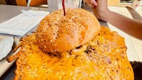 Burger ekstrem ini menambahkan parutan keju yang terlalu berlebihan. Keju yang telah dipanggang ini lebarnya hampir memenuhi meja pelanggan ketika siap disajikan. Foto: Bored Panda