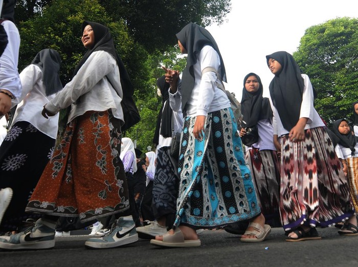 Sejumlah peserta bersiap memakai sarung saat mengikuti Jalan Sehat Sarungan di Salatiga, Jawa Tengah, Sabtu (4/2/2023). Jalan sehat menggunakan sarung yang diikuti 10 ribu peserta itu dalam rangka memperingati satu abad Nahdlatul Ulama serta menjaga tradisi sarung sebagai pakaian santri. ANTARA FOTO/Aloysius Jarot Nugroho/nym.