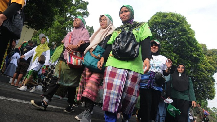 JALAN SEHAT MENGGUNAKAN SARUNG DI SALATIGA Sejumlah peserta bersiap memakai sarung saat mengikuti Jalan Sehat Sarungan di Salatiga, Jawa Tengah, Sabtu (4/2/2023). Jalan sehat menggunakan sarung yang diikuti 10 ribu peserta itu dalam rangka memperingati satu abad Nahdlatul Ulama serta menjaga tradisi sarung sebagai pakaian santri. ANTARA FOTO/Aloysius Jarot Nugroho/nym.