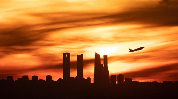 Dari Spanyol, ada siluet gedung pencakar langit di Madrid dan sebuah pesawat terbang saat matahari terbenam. Lanskap ini dijepret pada 12 Januari 2023. Dari Spanyol, ada siluet gedung pencakar langit di Madrid dan sebuah pesawat terbang saat matahari terbenam. Lanskap ini dijepret pada 12 Januari 2023.