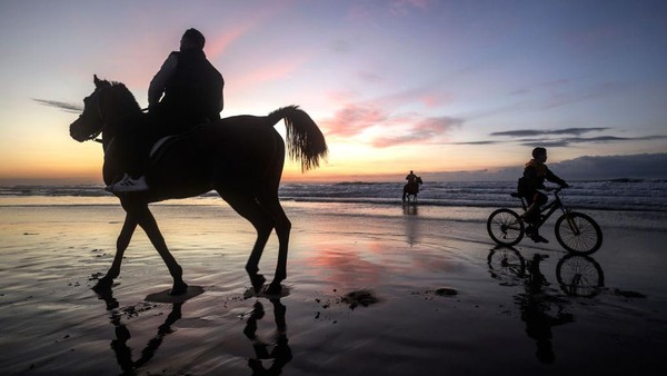 Siluet selanjutnya ada di pantai Gaza menampilkan warga Palestina yang menunggang kuda dan sepeda. Foto ini dijepret 3 Februari 2023.