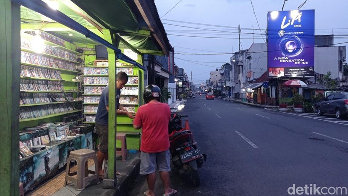 Pedagang VCD/DVD bajakan di Tasikmalaya sedang melayani pembeli.