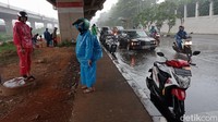 Para pengendara motor ini terpaksa berteduh untuk menghindari guyuran hujan.