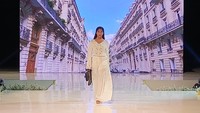 Model Ari Banerjee mengenakan rancangan bertema sederhana buatan Resort Wear dari Uluwatu Lace berwarna putih dengan tas hitam mungil.