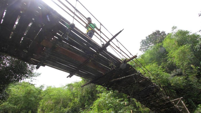 Jembatan Penghubung Antardesa di Kalsel Ini Rusak Sejak 7 Tahun Silam Seorang warga meniti jembatan gantung yang rusak di Desa Halunuk, Kabupaten Hulu Sungai Selatan, Kalimantan Selatan, Minggu (5/2/2023). Menurut warga setempat, jembatan gantung yang merupakan akses utama penghubung antardesa itu kondisinya telah rusak sejak tujuh tahun silam dan membahayakan bagi yang melintas, ANTARA FOTO/Bayu Pratama S/tom.