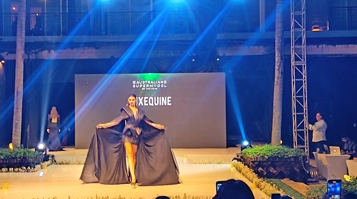 Model Ari Banerjee, malam ini ia mengenakan rancangan bertema sederhana buatan Resort Wear dari Uluwatu Lace berwarna putih dengan tas hitam mungil. (Triwidiyanti/detikBali)