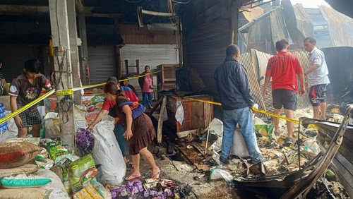 Para pedagang di Pasar Adat Lelateng memindahkan sisa barang dagangan yang tidak terbakar, Minggu (5/2/2023). (Foto: I Putu Adi Budiastrawan/detikBali)